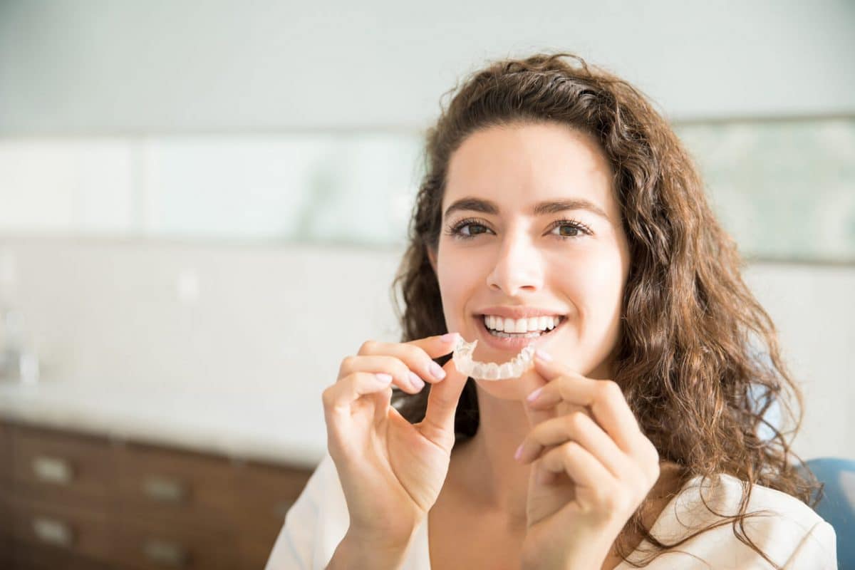 woman holding invisalign